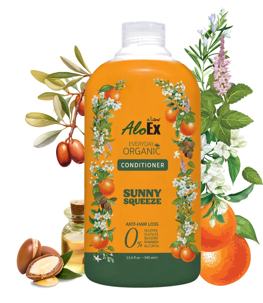 AloEx Everyday Organic Conditioner Sunny Squeeze bottle surrounded by flowers, oranges and argan nuts